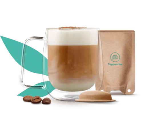 tazza con cappuccino accanto a una capsula e a una bustina a base carta