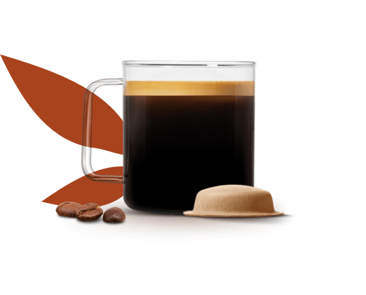 tazza piena di caffè preparato accanto a una capsula a base carta