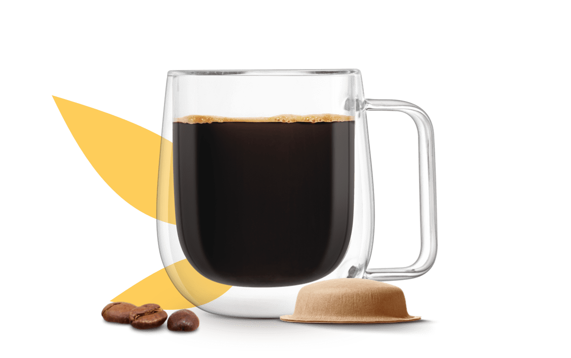 tazza di caffè accanto a una capsula in carta