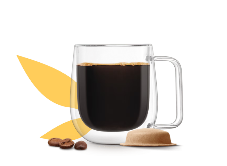 tazza di caffè accanto a una capsula in carta